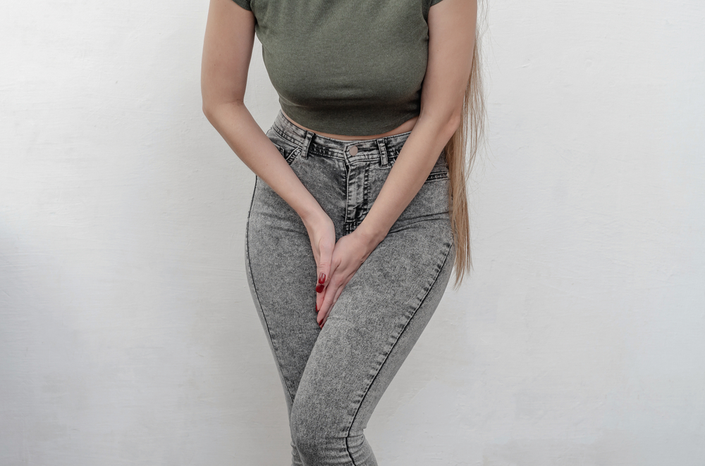 Young,Slim,Girl,In,Jeans,Holds,Hands,Pressed,Between,Her