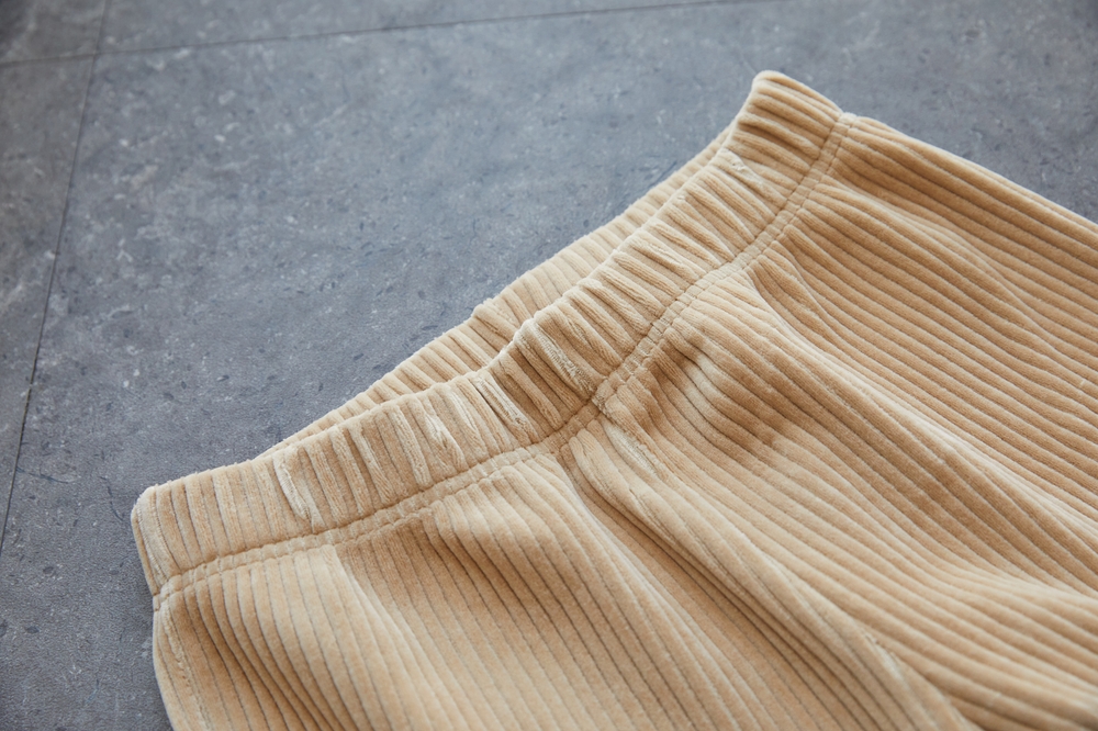 Beige,Corduroy,Fabric,Background,With,Waves,And,Elastic,For,Waistband.