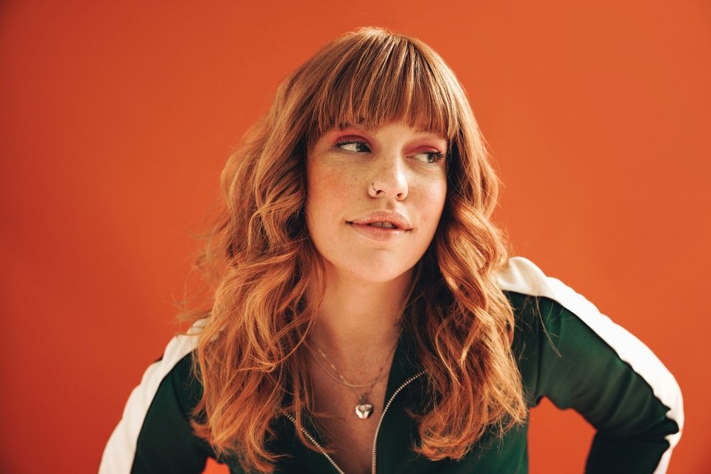 Woman,With,Ginger,Hair,Looking,Away,Thoughtfully,In,A,Studio.