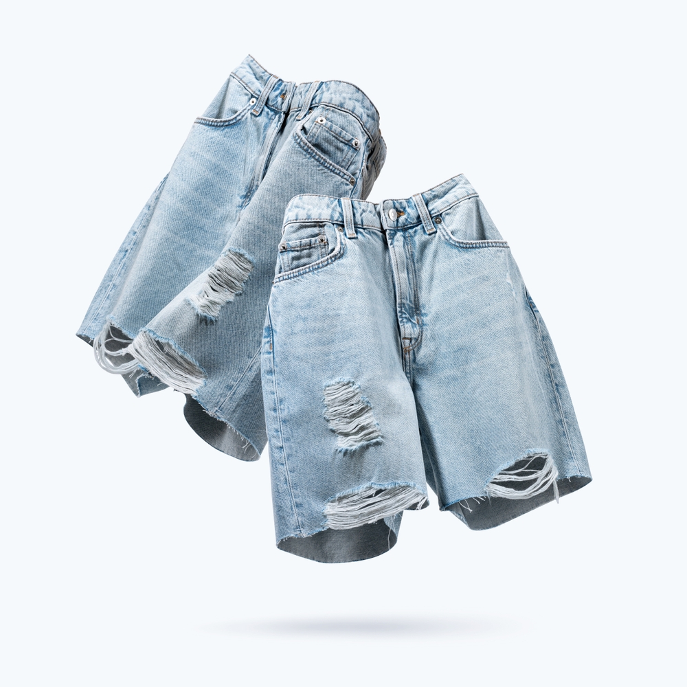 Ripped,Jeans,Shorts,Flying,On,Blue,Background.,Female,Fashionable,Denim