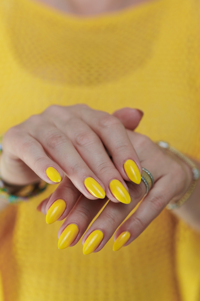 Female,Hand,With,Long,Nails,And,A,Bottle,Of,Bright