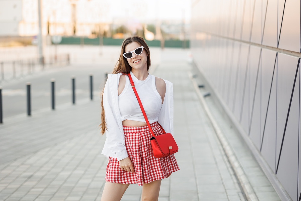 Smiling,Woman,Wearing,Red,And,White,Gingham,Skirt,White,Tank