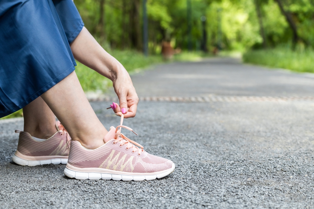 Woman,Unties,Laces,On,Sneakers,,Close-up.,Hand,Pulls,The,Lace