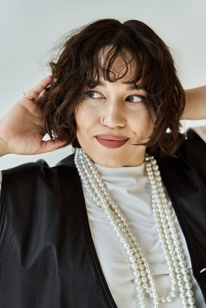 Woman,With,Short,,Curly,Hair,And,Pearl,Necklace,Gazes,Off-camera