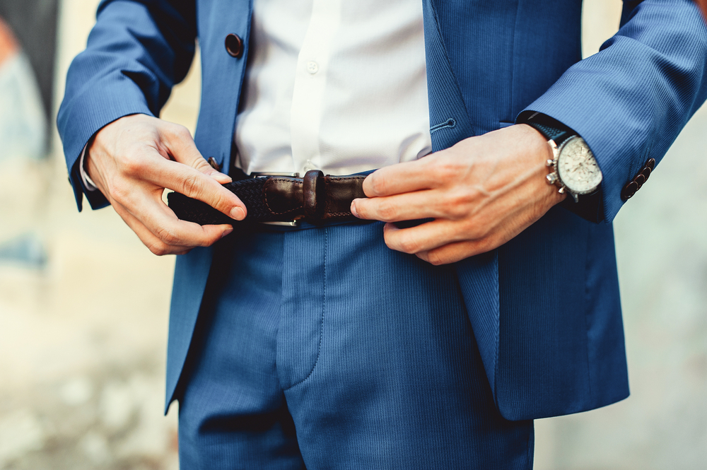 Groom,In,Blue,Pants,And,A,White,Shirt,Fastens,His